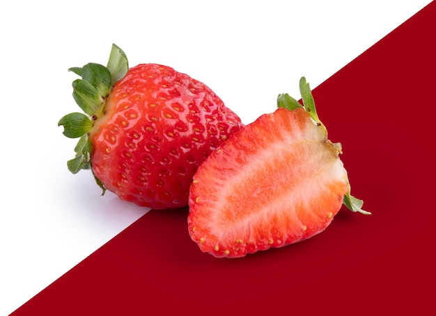 due fragole molto rosse una tagliata in fette isolate
