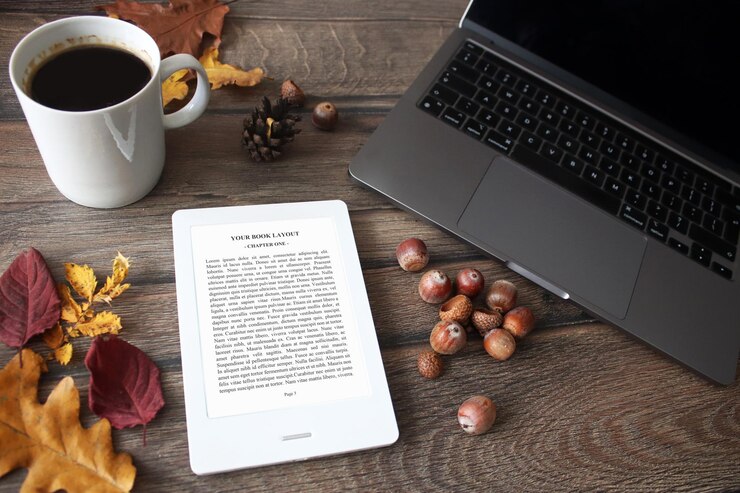 E-Book Reader Mock-Up con foglie autunnali, pigna, caffè, castagne e coperta e laptop