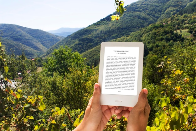 E-book reader, mockup, outdoor mit händen, naturhintergrund