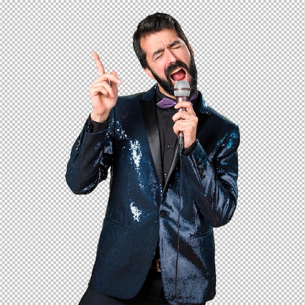 Ein hübscher Mann in einer Sequinjacke singt mit Mikrofon