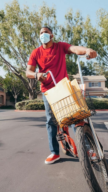 ein Mann, der ein rotes Hemd trägt, fährt auf einem Fahrrad mit einem Korb an der Vorderseite