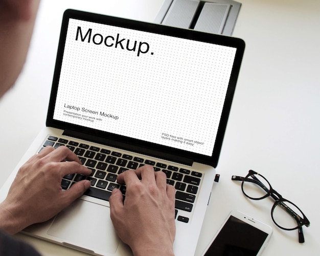 Ein Mann schreibt auf einem Laptop mit einem Bildschirmmodell