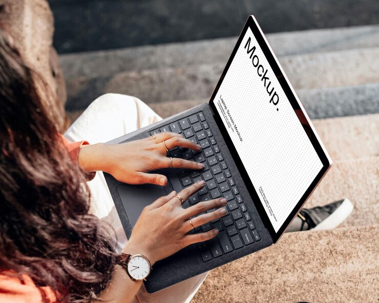 Eine Frau sitzt auf der Treppe und benutzt einen Laptop