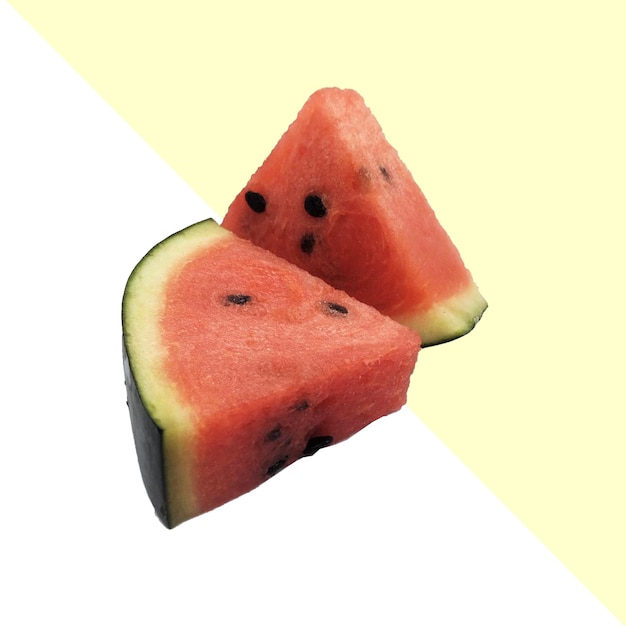 eine in zwei Teile geschnittene Wassermelone mit einem Stück Papier dahinter