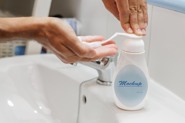 eine Person wäscht eine Flasche Mundwasser neben einem Waschbecken