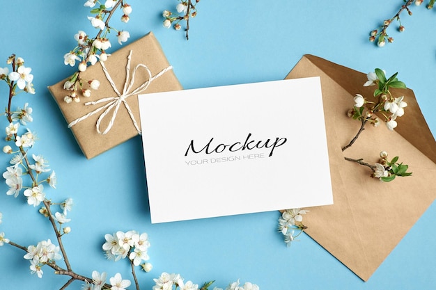 Einladungs- oder Grußkartenmodell mit Geschenkboxumschlag und Kirschbaumzweigen mit Blumen