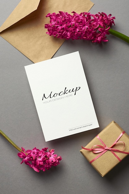 Einladungs- oder Grußkartenmodell mit Hyazinthenblumen und Geschenkbox auf grauem Hintergrund