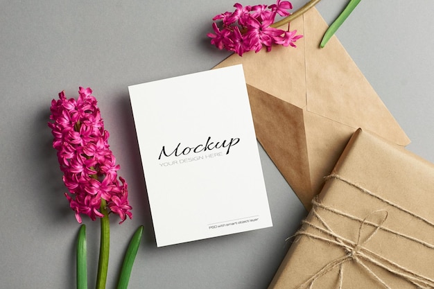 Einladungs- oder Grußkartenmodell mit Hyazinthenblumen und Geschenkbox auf grauem Hintergrund