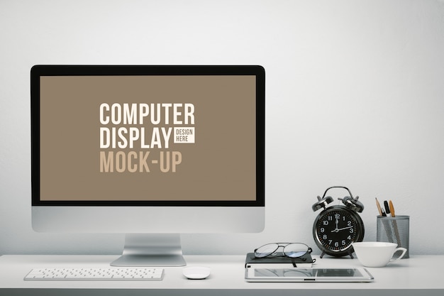 Elegante espacio de trabajo con pantalla de computadora en blanco y tableta para maqueta en mesa de trabajo con teclado, mouse, reloj, anteojos y papelería