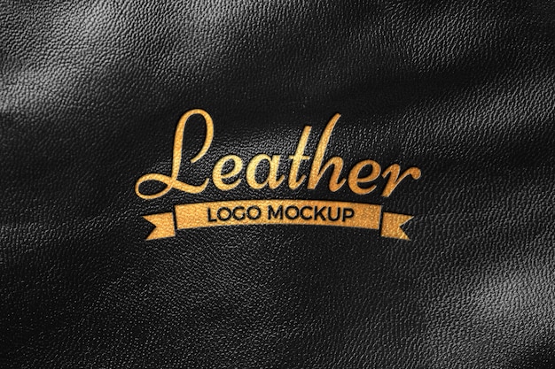 PSD elegante logotipo dorado sobre material de cuero negro.