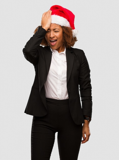 La empresaria negra joven que lleva un sombrero de santa de la Navidad olvidadizo, realiza algo