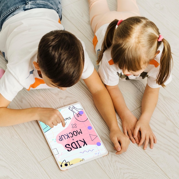 Enfants De Tir Moyen Sur Le Sol Avec Tablette