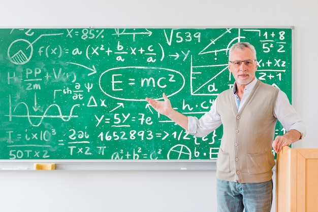 Enseignant montrant un tableau plein de formules