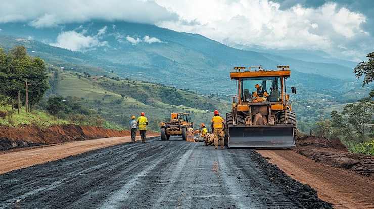PSD un equipo de construcción de carreteras pavimentando una nueva carretera de asfalto en una región montañosa 1