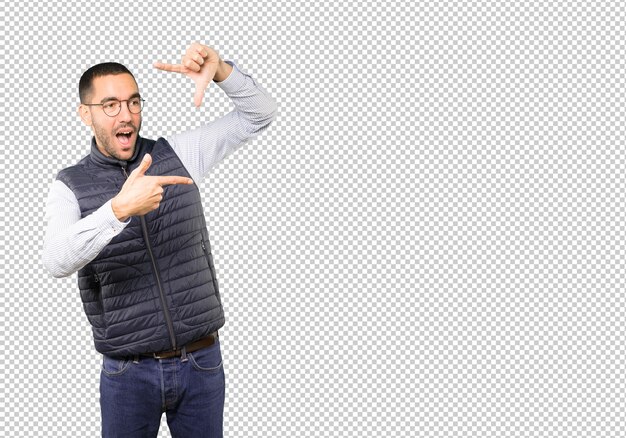 Erstaunter junger Mann, der eine Geste macht, ein Foto mit den Händen zu machen