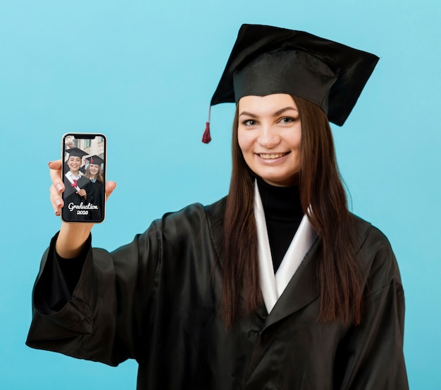 Estudiante feliz graduación con teléfono móvil