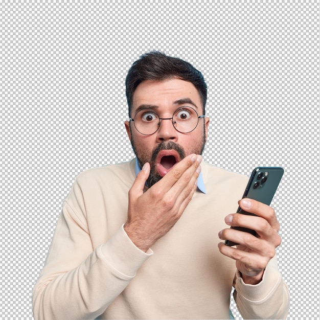 Estupefacto, barbudo, adulto, europeu, mantém a boca aberta, olha aterrorizado, segura o telemóvel, descobre notícias chocantes, vestido com um casaco casual.
