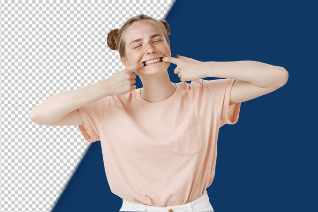 PSD Étudiante caucasienne enfantine et enjouée dans un t-shirt rose élégant avec des taches de rousseur tirant la bouche
