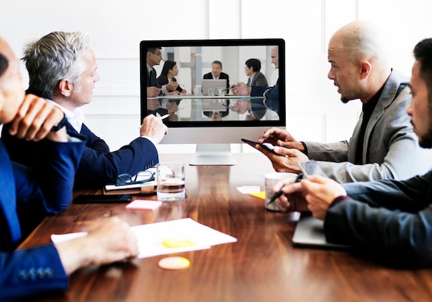 Executivos em uma reunião de conferência usando uma maquete de tela de computador