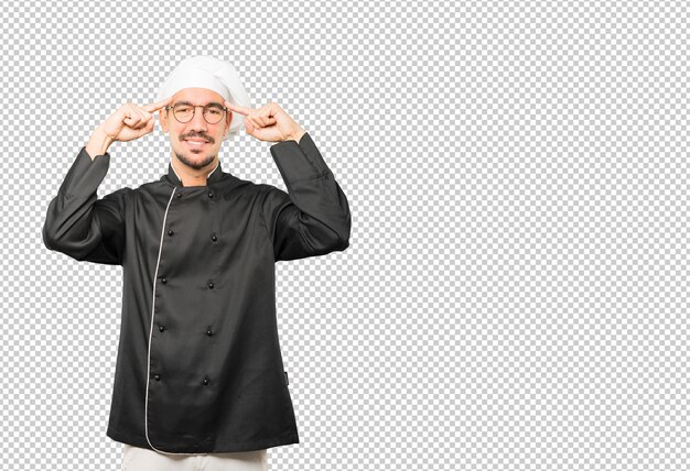 Felice giovane chef facendo un gesto di concentrazione