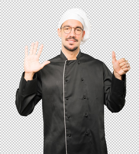 Feliz jovem chef fazendo um gesto de número seis com as mãos