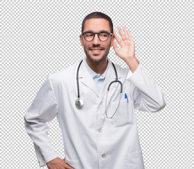 Feliz jovem médico com um gesto de tentar ouvir com a mão