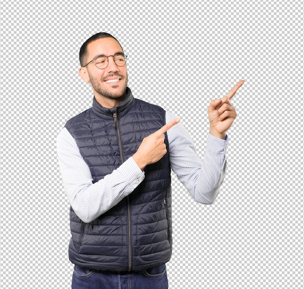 Feliz joven apuntando hacia arriba con su dedo