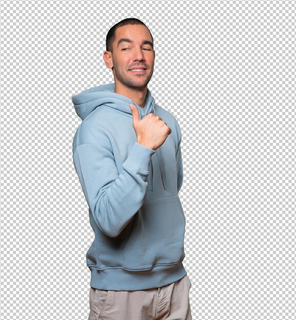 Feliz joven apuntando con su pulgar