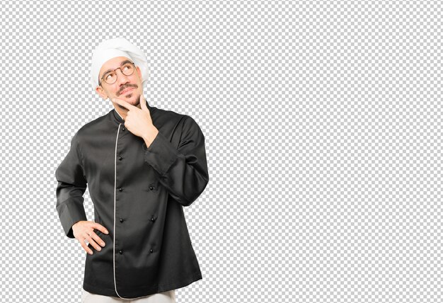 Feliz joven chef haciendo un gesto de duda