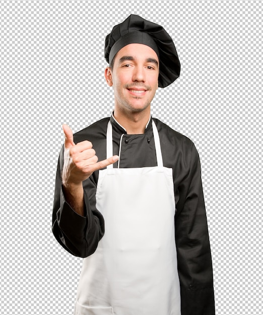 Feliz joven chef haciendo un gesto de llamada