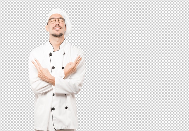 Feliz joven chef haciendo un gesto de victoria con sus dedos