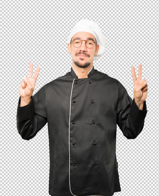 Feliz joven chef haciendo un gesto de victoria con sus dedos