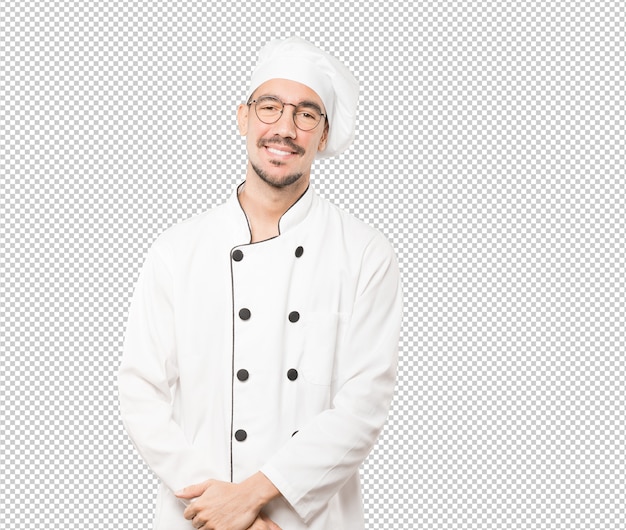 Feliz joven chef posando sobre fondo