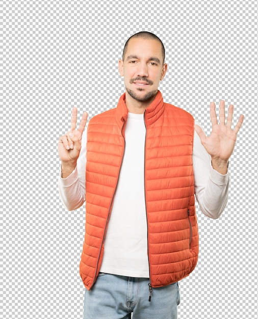 Feliz joven haciendo un gesto número siete con las manos