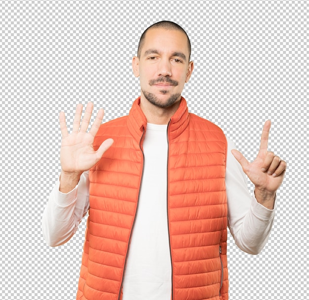 Feliz joven haciendo un gesto número siete con sus manos