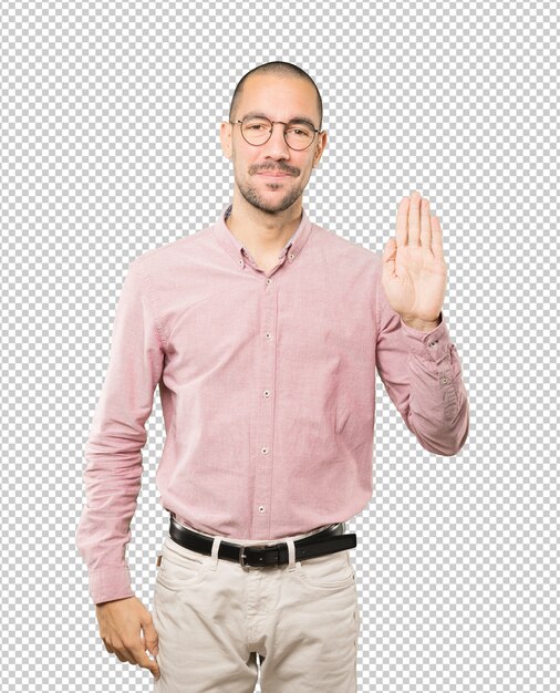 Feliz joven haciendo un gesto de parada con la palma de la mano