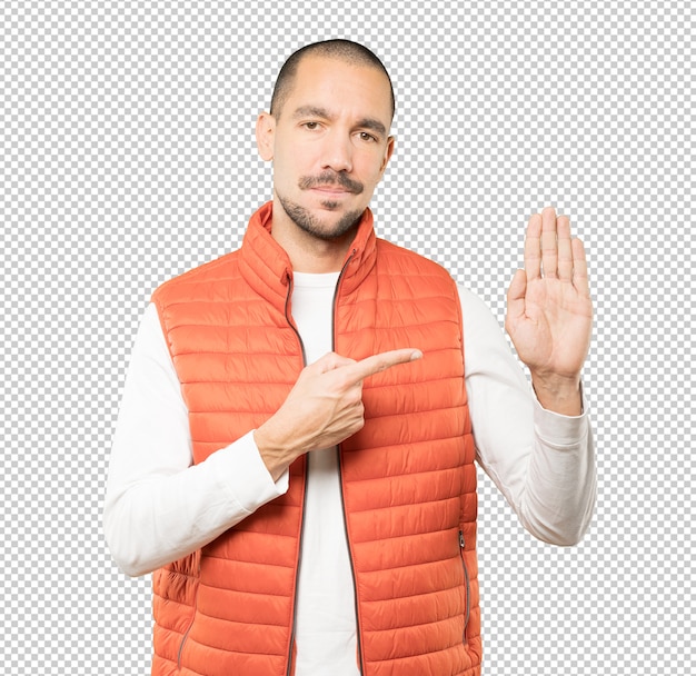 Feliz joven haciendo un gesto de parada con la palma de la mano