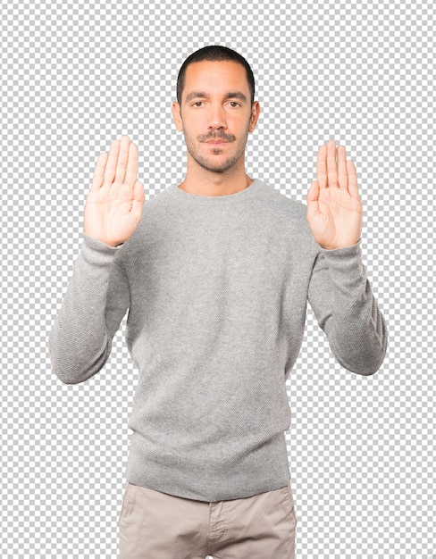 Feliz joven haciendo un gesto de parada con la palma de la mano