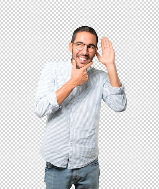 Feliz joven sonriendo y haciendo un gesto de intentar escuchar algo