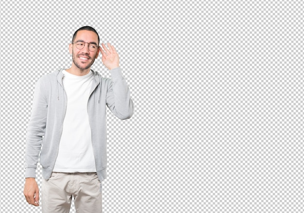 Feliz joven sonriendo y haciendo un gesto de intentar escuchar algo