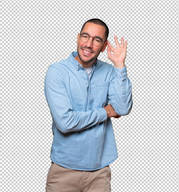 Feliz joven sonriendo y haciendo un gesto de intentar escuchar algo