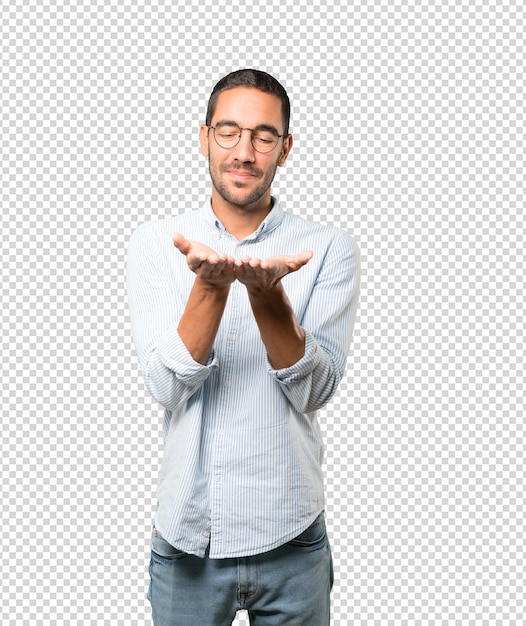 Feliz joven sosteniendo algo con la mano
