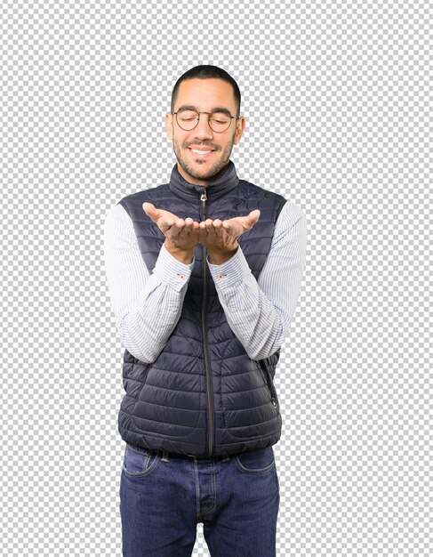 Feliz joven sosteniendo algo con la mano