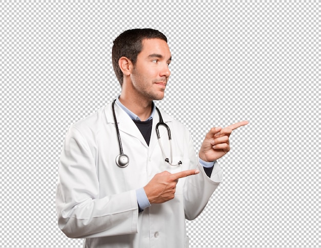 Feliz médico apontando contra fundo branco