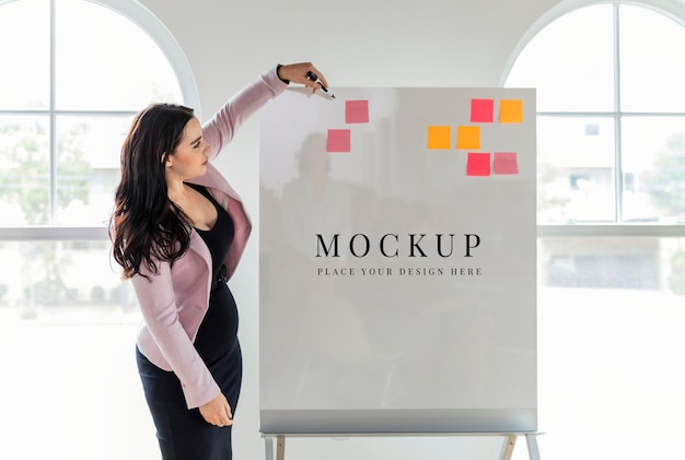 Une femme d'affaires écrivant sur un modèle de tableau blanc
