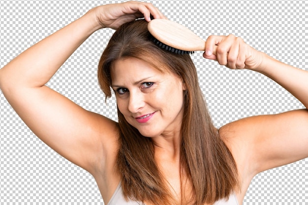 Femme d'âge moyen sur un fond isolé avec un peigne à cheveux