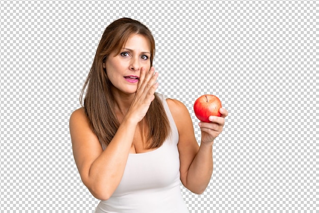 Une Femme D'âge Moyen Avec Une Pomme Sur Un Fond Isolé Murmurant Quelque Chose