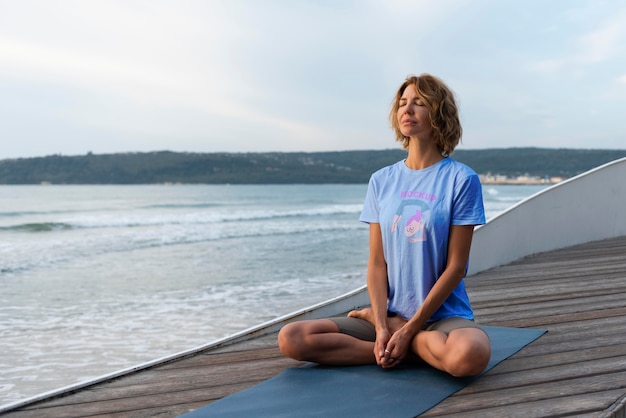 PSD femme faisant du yoga avec un design de maquette de chemise