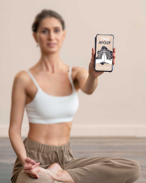 PSD femme faisant du yoga et tenant un smartphone