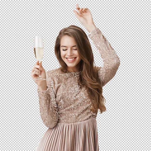 Une femme insouciante dansant en robe de soirée tenant un verre de champagne.